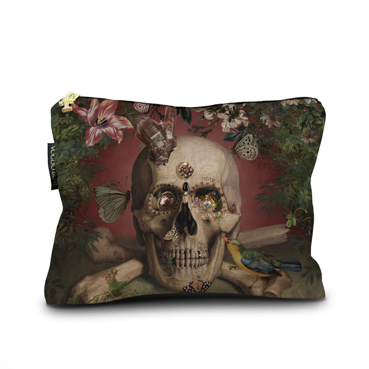 Kuvassa Voglio Bene samettilaukun etupuoli Eternity -kuvituksella, jossa pääkallon silmistä roikkuu kimaltavia koruja, ja punaista taustaa koristavat linnut, kasvit ja perhoset.
In the image, the front side of a Voglio Bene velvet bag with the Eternity illustration, showing a skull with sparkling jewelry hanging from its eyes, surrounded by birds, plants, and butterflies on a red background.