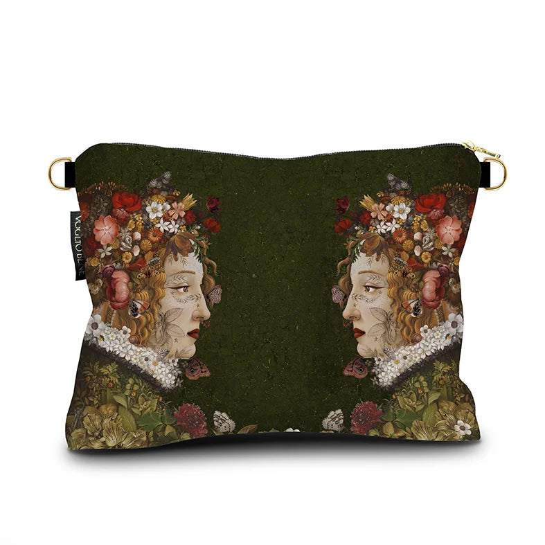 Kuvassa Voglio Bene -samettilaukun takapuoli Flora -kuvituksella. Kaksi tatuoitua punahiuksista naista kukkia hiuksissaan katsovat toisiaan vihreällä taustalla.
The back of the Voglio Bene velvet bag with Flora illustration. Two tattooed red-haired women with flowers in their hair face each other against a green background.