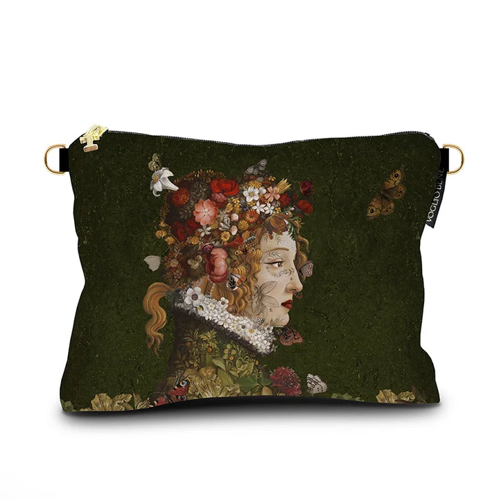 Kuvassa Voglio Bene -samettilaukku Flora -kuvituksella. Sivuprofiilissa tatuoitu punahiuksinen nainen, kukkia hiuksissaan ja perhosia ympärillään vihreällä taustalla.
The Voglio Bene velvet bag with Flora illustration. A tattooed red-haired woman in profile with flowers in her hair is surrounded by butterflies against a green background.