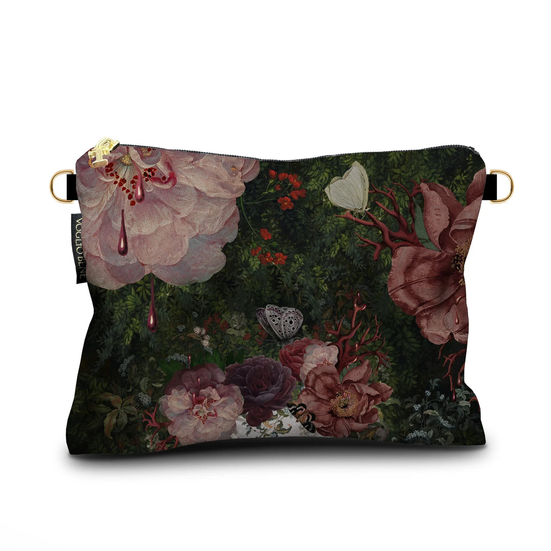 Kuvassa Voglio Bene samettilaukun takapuoli Gaia -kuvituksella, jossa sankka vihreä kasvusto täynnä kukkia, koralleja ja perhosia.
In the image, the back side of a Voglio Bene velvet bag with the Gaia illustration, showing dense green foliage filled with flowers, corals, and butterflies.