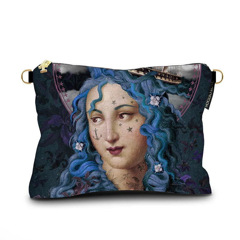 Kuvassa Voglio Bene -samettilaukun takapuoli Holy Storm -kuviolla. Lähikuva tatuoidusta sinihiuksisesta naisesta.
The back of the Voglio Bene velvet bag with Holy Storm illustration. Close-up of the tattooed blue-haired woman.