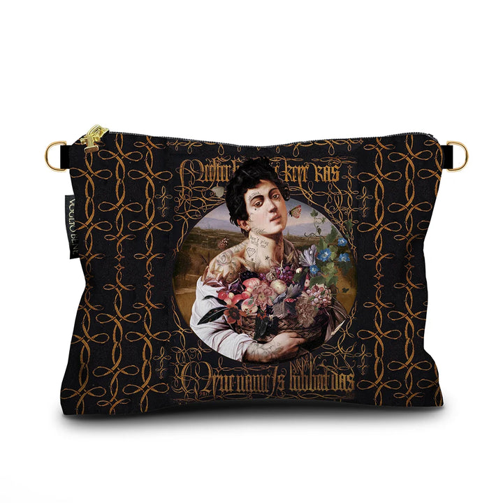 Kuvassa Voglio Bene samettilaukun etupuoli I’m Sexy -kuvituksella, jossa tatuoitu nainen pitää kukkakoria kädessään tummalla taustalla.
In the image, the front side of a Voglio Bene velvet bag with the I’m Sexy illustration, depicting a tattooed woman holding a basket of flowers against a dark background.