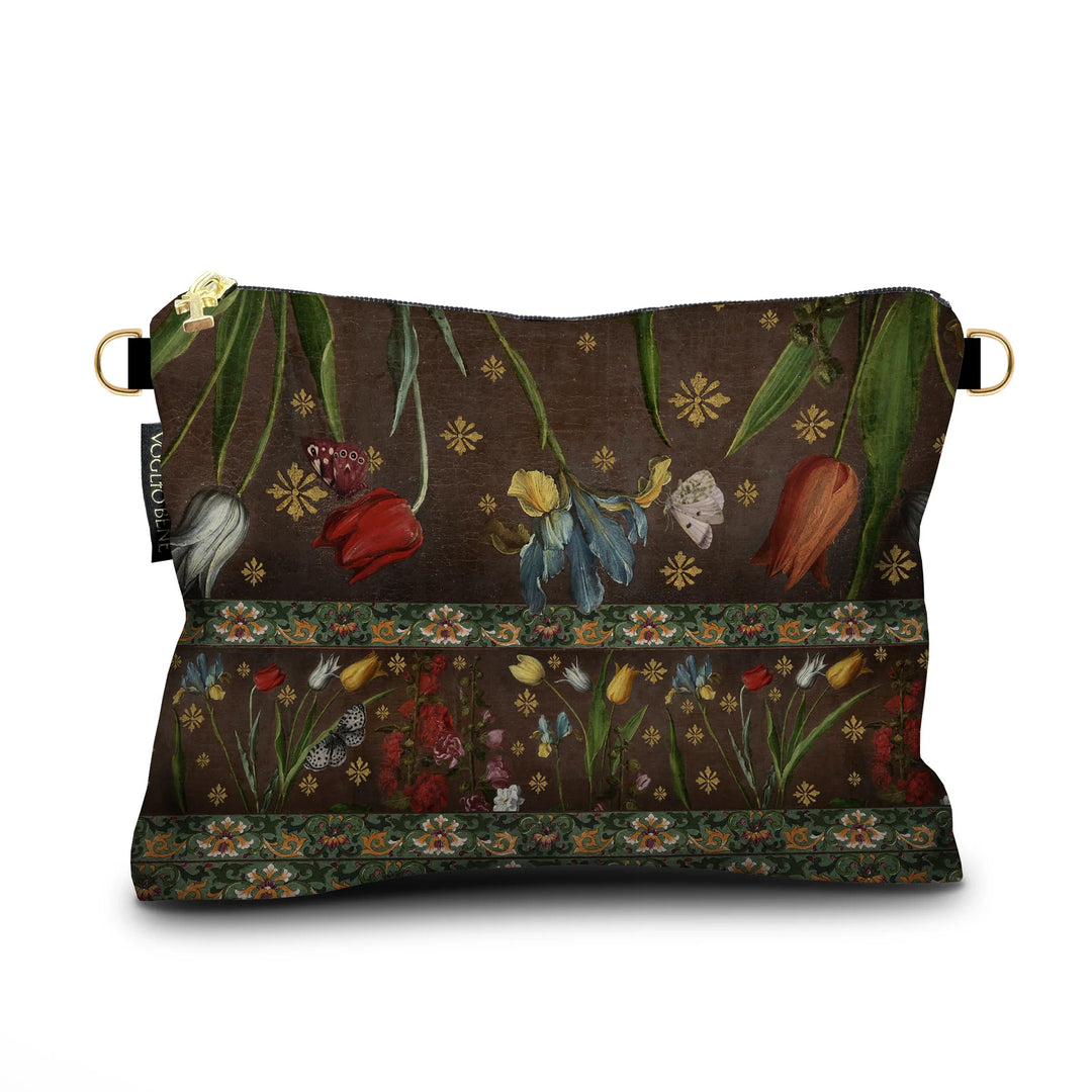 Kuvassa Voglio Bene -samettilaukun takapuoli Jolly-kuvituksella. Kukat ja ornamenttikuvio ruskealla taustalla.
The back of the Voglio Bene velvet bag with the Jolly illustration. Flowers and ornamental patterns on a brown background.