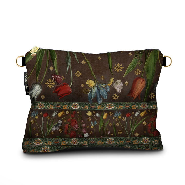 Kuvassa Voglio Bene -samettilaukun takapuoli Jolly-kuvituksella. Kukat ja ornamenttikuvio ruskealla taustalla.
The back of the Voglio Bene velvet bag with the Jolly illustration. Flowers and ornamental patterns on a brown background.