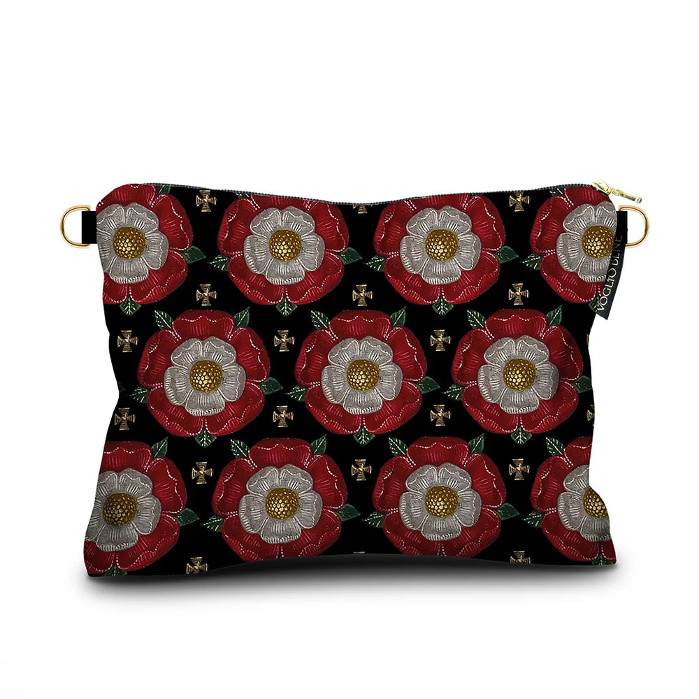 Kuvassa Voglio Bene -samettilaukun takapuoli Notre Dame -kuvituksella. Kukat toistuvat geometrisessa sommittelussa tummalla taustalla.
The back of the Voglio Bene velvet bag with Notre Dame illustration. The flowers are repeated in a geometric arrangement on a dark background.