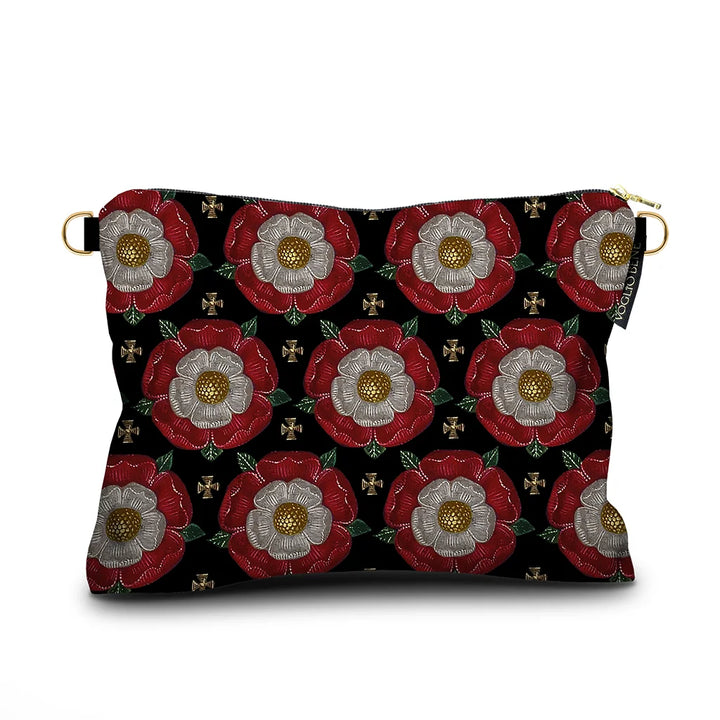 Kuvassa Voglio Bene -samettilaukun takapuoli Notre Dame -kuvituksella. Kukat toistuvat geometrisessa sommittelussa tummalla taustalla.
The back of the Voglio Bene velvet bag with Notre Dame illustration. The flowers are repeated in a geometric arrangement on a dark background.