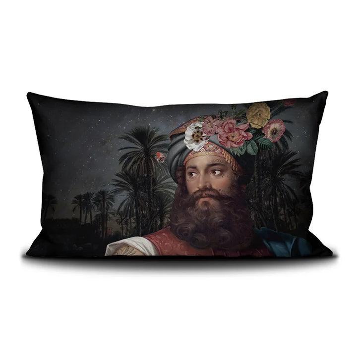 Voglio Bene The Great Belzoni -tyynyn etunäkymä, jossa tatuoitu arabialainen mies on kuvattu yömaisemassa palmujen ja tähtitaivaan reunustamana.
Front view of a Voglio Bene The Great Belzoni cushion, showing a tattooed Arab man in a night scene framed by palm trees and a starry sky.