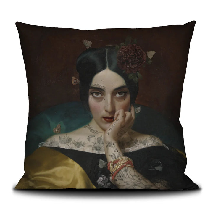 Kuvassa Voglio Bene tyynyn etupuoli Clementine -kuvituksella, jossa tatuoitu nainen tummanpunaisella taustalla katsoo intensiivisesti kohti katsojaa.
In the image, the front side of a Voglio Bene cushion with the Clementine illustration, depicting a tattooed woman on a dark red background gazing intensely at the viewer.