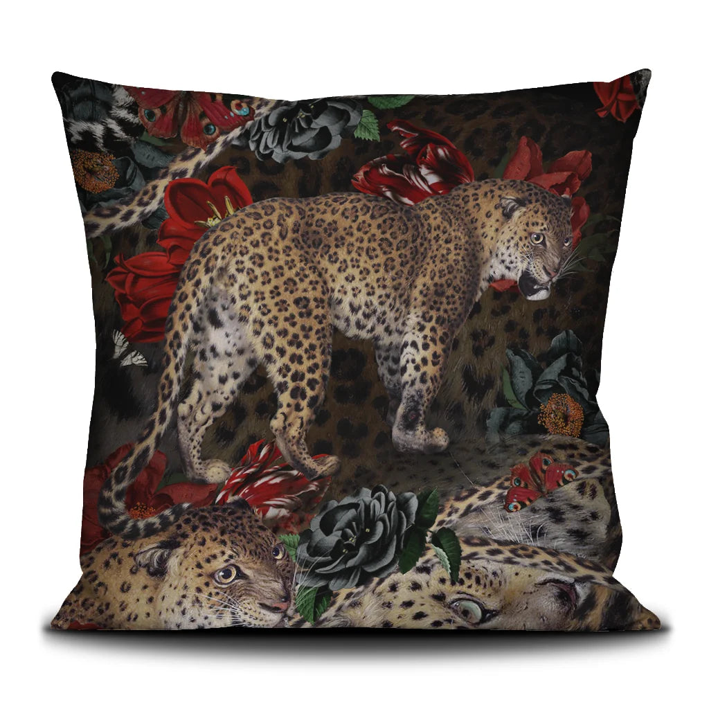 Kuvassa Voglio Bene -tyyny Fauve-kuvituksella. Edessä leopardi tummalla taustalla kukkien ja perhosten reunustamana.
The front of the Voglio Bene cushion with the Fauve illustration. A leopard on a dark background surrounded by flowers and butterflies.