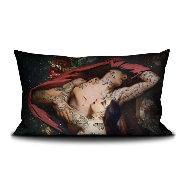 Kuvassa Voglio Bene -tyyny Francesca et Paolo -kuvituksella. Edessä tatuoitu nainen syleilee tatuoitua miestä, jonka kasvot on peitetty punaisella liinalla. Taustalla avaruus ja kukkia.
The front of the Voglio Bene cushion with the Francesca et Paolo illustration. A tattooed woman embraces a tattooed man whose face is covered with a red cloth, set against a cosmic background with flowers.