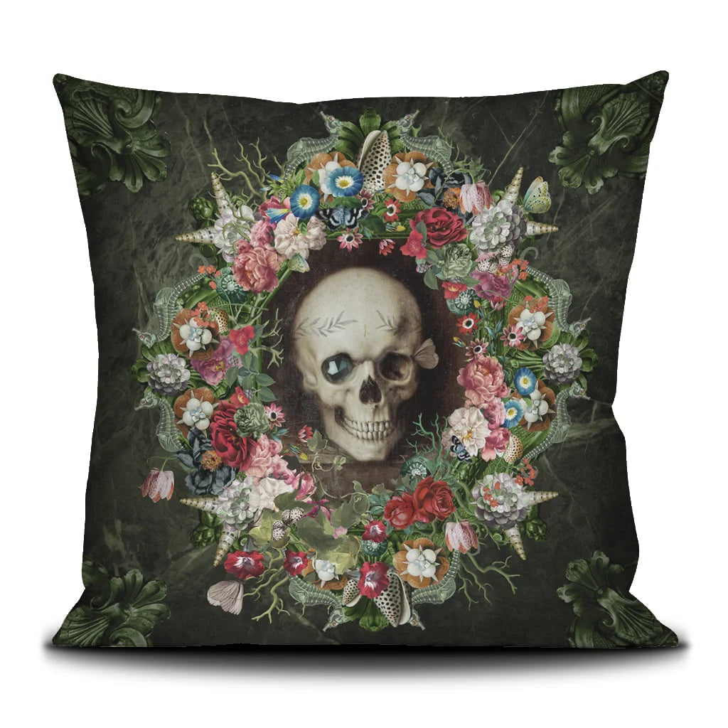 Voglio Bene The Froth of the Days -tyynyn etunäkymä, jossa pääkalloa koristavat kukat ja simpukat yksityiskohtaisessa kuvituksessa.
Front view of a Voglio Bene The Froth of the Days cushion, showing a skull adorned with flowers and seashells in detailed artwork.