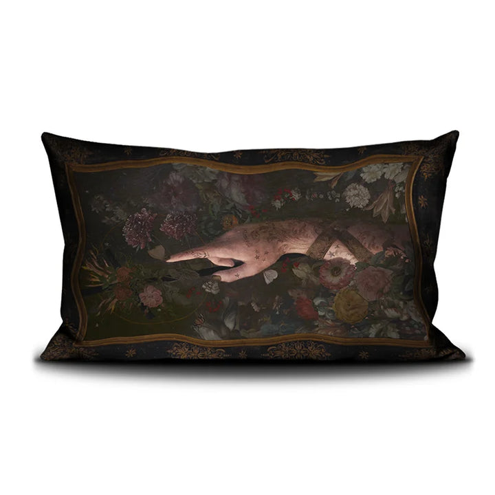 Kuvassa Voglio Bene -tyyny Il Battista -kuvituksella. Edessä tatuoitu käsi nousee kukkien seasta ja osoittaa vasemmalle.
The front of the Voglio Bene cushion with the Il Battista illustration. A tattooed hand emerges from flowers, pointing to the left.