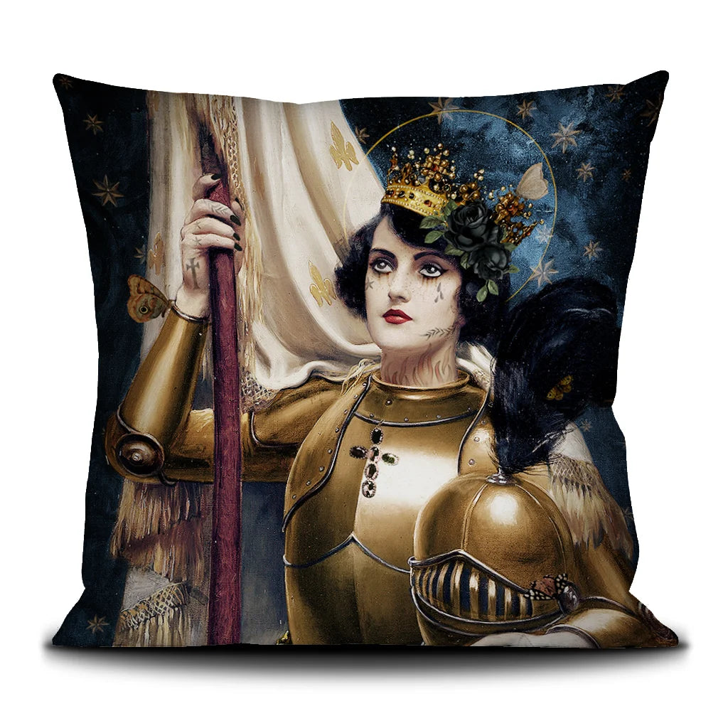 Kuvassa Voglio Bene -tyyny Saint Jeanne -kuvioinnilla. Tatuoitu mustahiuksinen nainen kultaisessa haarniskassa, kruunu ja musta ruusu päässä, pitää lippua tähtitaivasta vasten.
The Voglio Bene cushion with Saint Jeanne pattern. A tattooed dark-haired woman in golden armor, wearing a crown and a black rose, holds a banner against a starry sky.