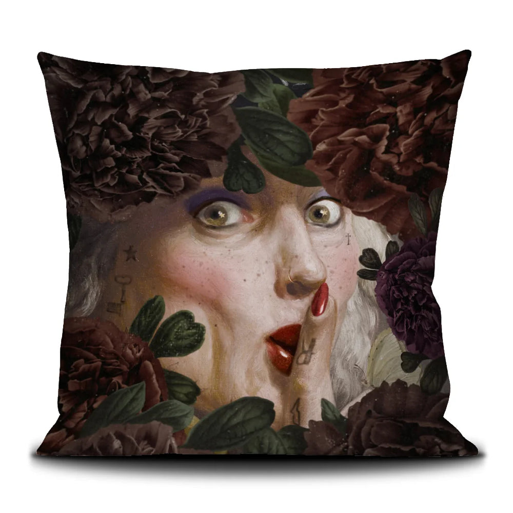 Kuvassa Voglio Bene -tyynyn takapuoli The Key Woman -kuvituksella. Lähikuva kasvoista kukkien vieressä.
The back of the Voglio Bene cushion with The Key Woman illustration. Close-up of the face beside flowers.