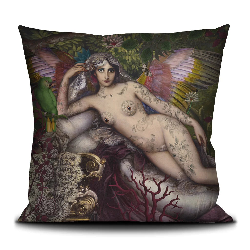 Kuvassa Voglio Bene -tyyny A Midsummer Night’s Dream -kuviolla. Alaston tatuoitu siivekäs nainen makaa taustanaan metsä, kukkia ja perhosia.
The Voglio Bene cushion with A Midsummer Night’s Dream pattern. A nude tattooed winged woman lies against a background of forest, flowers, and butterflies.