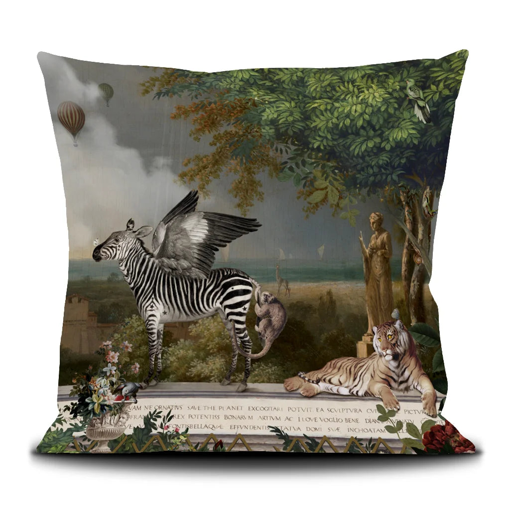 Kuvassa Voglio Bene -tyyny Noe-kuvituksella. Pegasus-seepra, apinoita ja tiikeri oleskelevat antiikkisessa ympäristössä, taustalla avomaa, ranta, meri ja laivoja.
The Voglio Bene cushion with Noe illustration. A Pegasus-zebra, monkeys, and a tiger rest in an antique setting with open land, a beach, the sea, and ships in the background.