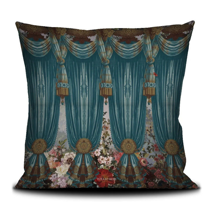 Voglio Bene Paradise -tyynyn takanäkymä. Kuvassa siniset verhot, trooppisia kukkia ja kasveja koristeellisena taustakuviona.
Back view of a Voglio Bene Paradise cushion. The image features blue curtains, tropical flowers and plants forming a decorative background pattern.
