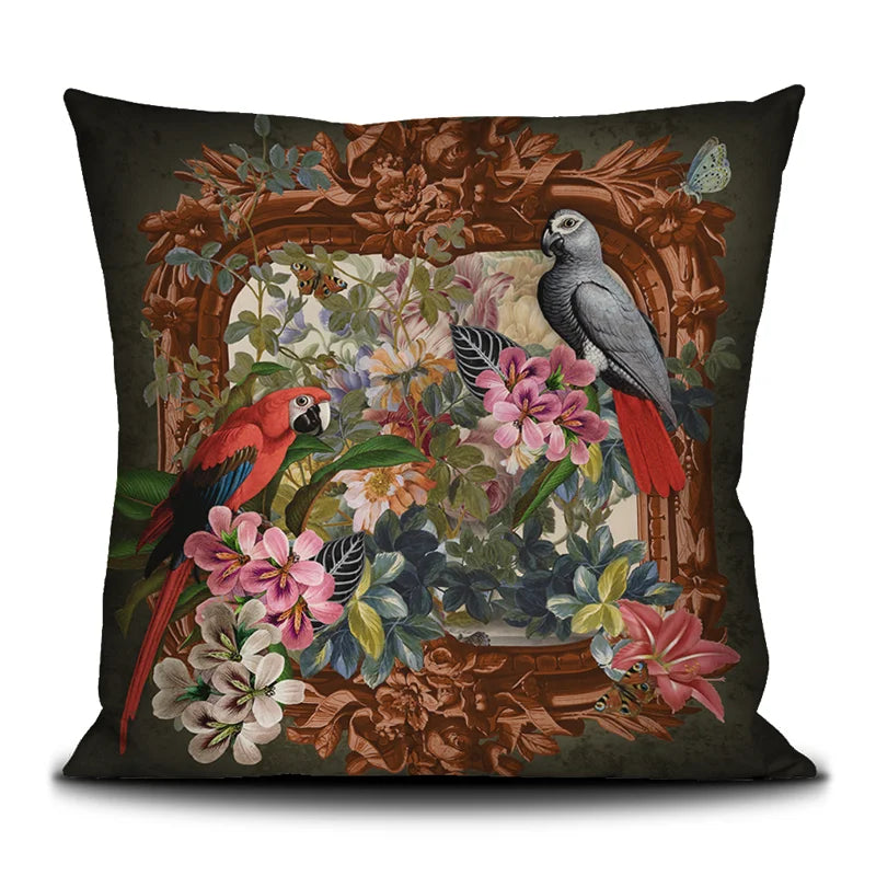 Voglio Bene Parrot -tyynyn etunäkymä. Kuvassa kaksi papukaijaa istuu kukkaornamentti-asetelmassa rehevän taustan edessä.
Front view of a Voglio Bene Parrot cushion. The illustration shows two parrots perched within a floral ornamental arrangement against a lush backdrop.