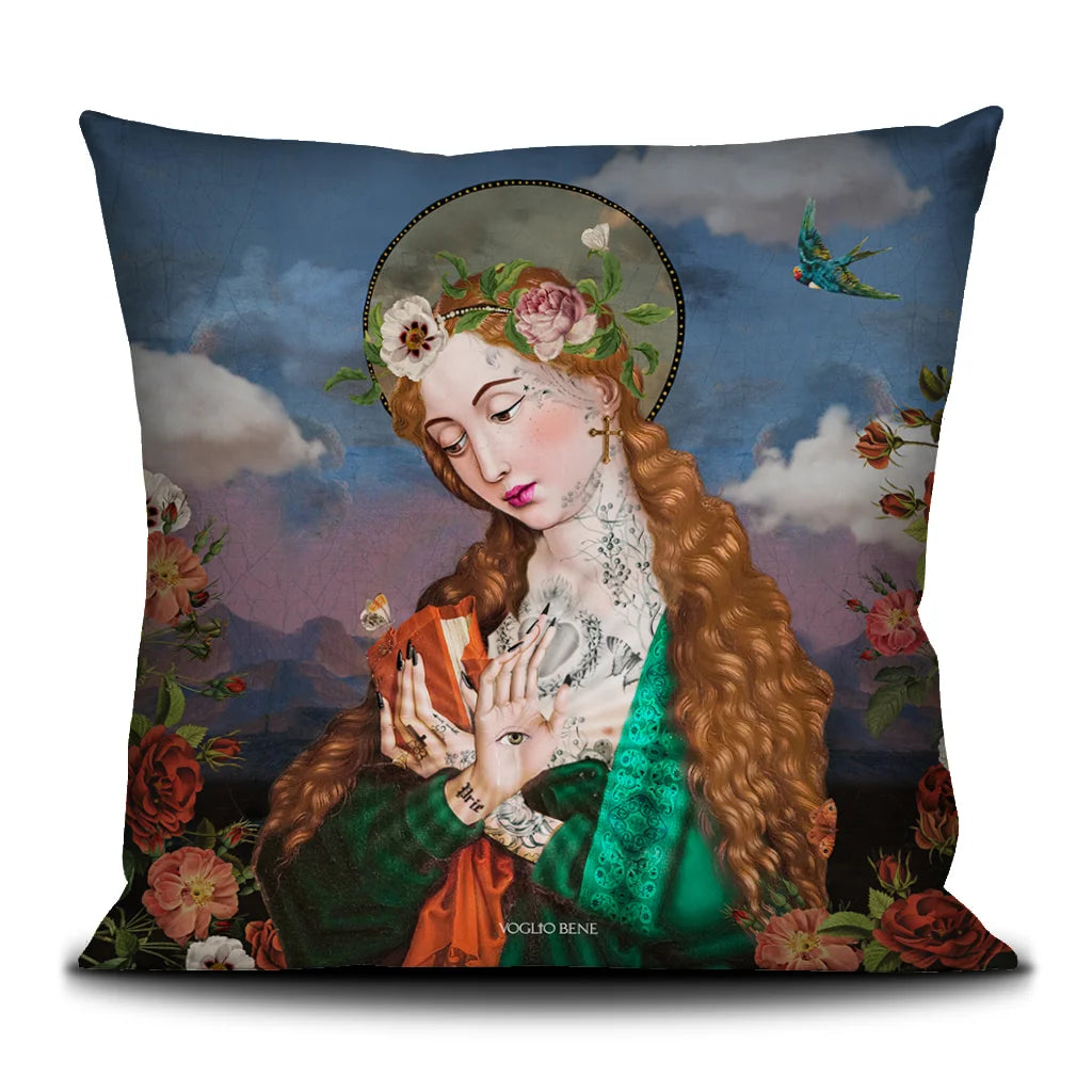Voglio Bene Pray-tyynyn takanäkymä, jossa punahiuksinen nainen vihreässä kaavussa on kuvattu lähempää. Nainen pitelee kirjaa kädessään ja toisessa kämmenessä on silmäsymboli. Taustalla pilvinen vuorimaisema ja kukkia.
Back view of Voglio Bene Pray -cushion featuring a cropped image of the red-haired woman in a green robe. She is holding a book in one hand and an eye symbol in the palm of the other. The background depicts a cloudy mountain landscape with flowers.