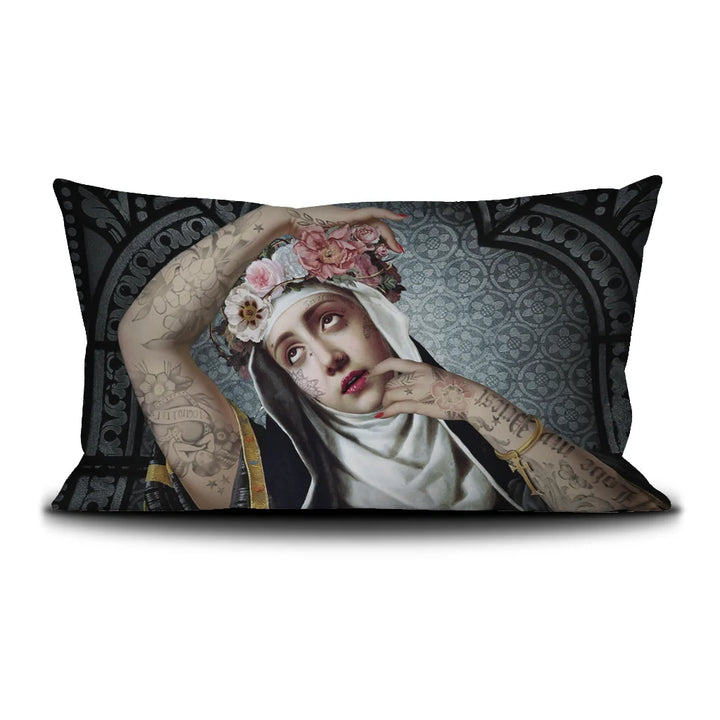 Kuvassa Voglio Bene tyynyn etupuoli Saint Rita -kuvituksella, jossa tatuoitu nunna kukkaseppele päässä on kuvattuna tummalla ornamenttikuvioisella taustalla.
In the image, the front side of a Voglio Bene cushion with the Saint Rita illustration, depicting a tattooed nun wearing a flower crown against a dark ornamental background.