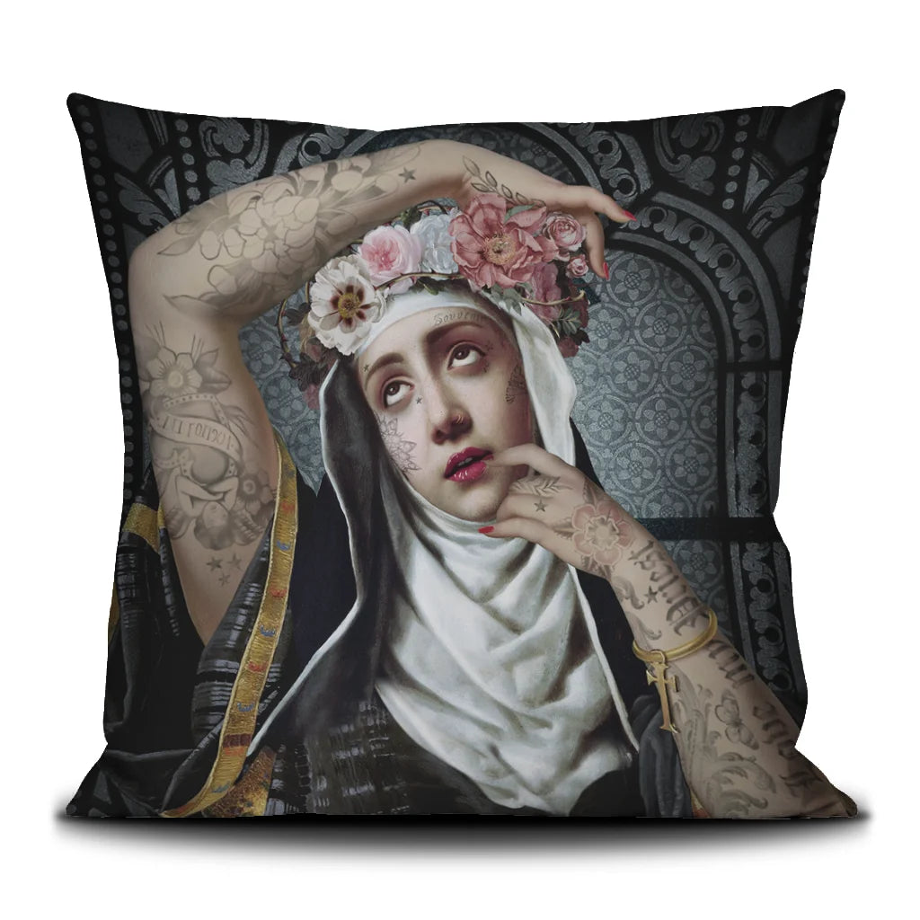 Kuvassa Voglio Bene tyynyn etupuoli Saint Rita -kuvituksella, jossa tatuoitu nunna kukkaseppele päässä on kuvattuna tummalla ornamenttikuvioisella taustalla.
In the image, the front side of a Voglio Bene cushion with the Saint Rita illustration, depicting a tattooed nun wearing a flower crown against a dark ornamental background.