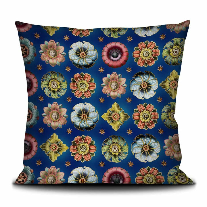 Voglio Bene Rosettes-tyynyn etupuoli, inspiroitu keskiaikaisten ja renessanssiajan rosettien symboliikasta sinisellä taustalla.  Voglio Bene Rosettes cushion front view, inspired by the symbolism of medieval and Renaissance rosettes with a blue backround.