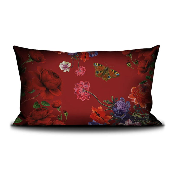 Kuvassa Voglio Bene tyynyn takapuoli Shut Up -kuvituksella, jossa punainen tausta ja kukat jatkuvat perhosten kera.
In the image, the back side of a Voglio Bene cushion with the Shut Up illustration, showing the continuation of the red background and flowers with butterflies.