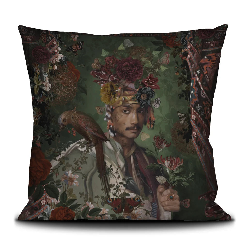 Kuvassa Voglio Bene -tyyny Sultan-kuvituksella. Tatuoitu viiksekäs mies kukkaturbaani päässä ja papukaija olalla poseeraa vihreällä taustalla kukkien ympäröimänä.
The Voglio Bene cushion with Sultan illustration. A tattooed man with a floral turban and a parrot on his shoulder poses against a green background surrounded by flowers.