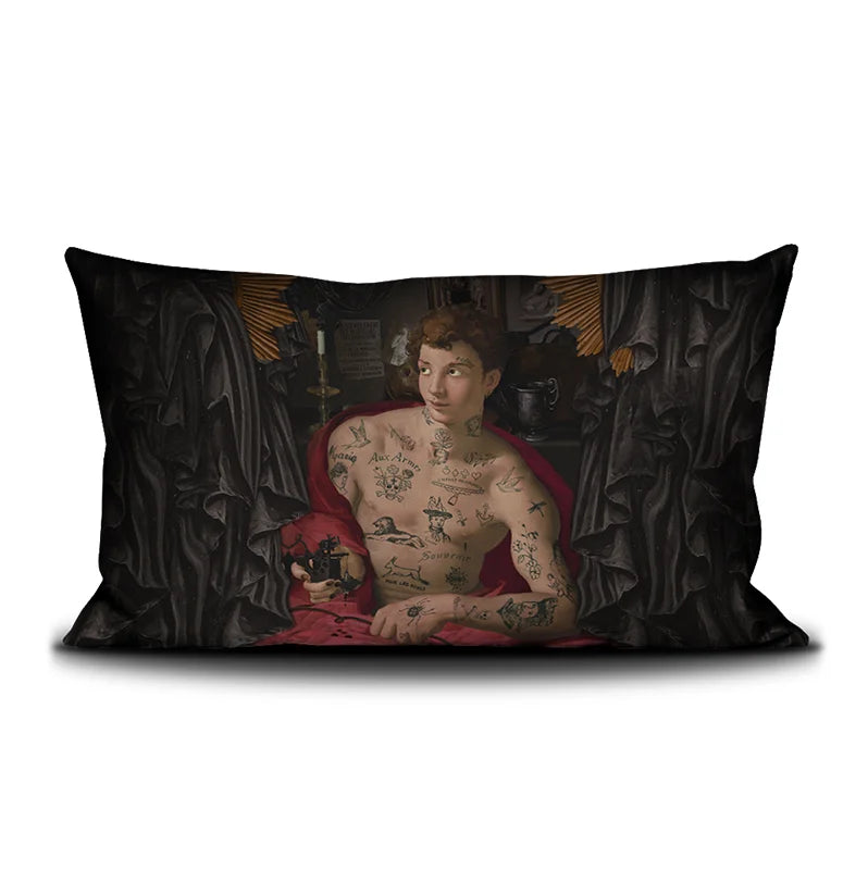 Voglio Bene Tattoo Artist’s Kit -tyynyn etunäkymä, jossa tatuoitu tatuoija on kuvattu punaisessa viitassa.
Front view of a Voglio Bene Tattoo Artist’s Kit cushion, featuring a tattooed tattoo artist wearing a red cloak.