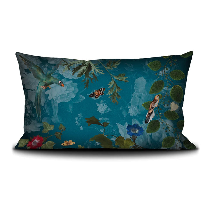 Kuvassa Voglio Bene -tyynyn takapuoli Tree of Life -kuvituksella. Papukaija ja perhonen lentävät kasvien koristamalla sinisellä taustalla.
The back of the Voglio Bene cushion with the Tree of Life illustration. A parrot and a butterfly flying against a blue background decorated with plants.