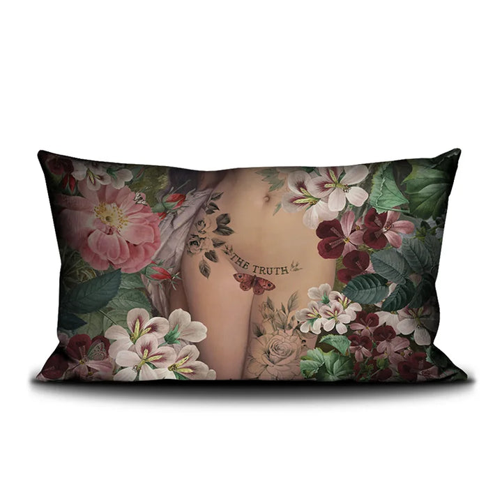 Kuvassa Voglio Bene The Truth -tyyny kuvituksella. Tatuoidun naisen lantio lähikuvassa kukkien ympäröimänä.
Voglio Bene cushion with The Truth illustration. A tattooed nude woman's hips in a cropped image are surrounded by flowers.