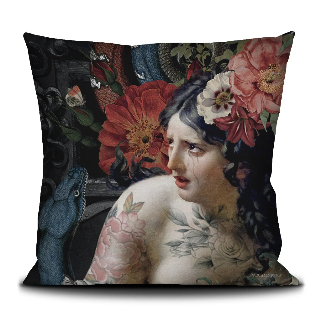Kuvassa Voglio Bene tyynyn takapuoli Turmoil -kuvituksella, jossa itkevä tatuoitu nainen on kuvattuna läheltä kukkien ja käärmeiden ympäröimänä tummalla taustalla.
In the image, the back side of a Voglio Bene cushion with the Turmoil illustration, depicting a crying tattooed woman up close surrounded by flowers and snakes against a dark background.