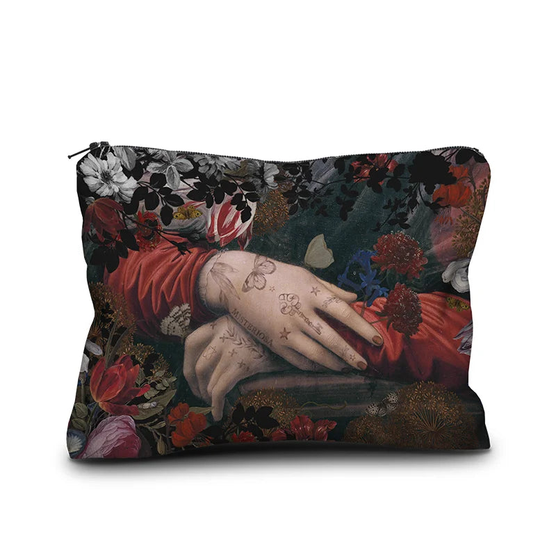 Voglio Bene Misteriosa -samettipussukan etunäkymä, koko 17 × 23 cm. Kuvassa Mona Lisasta muokattu versio, jossa tatuoidut kädet ovat esillä kukkien reunustamana.
Front view of a Voglio Bene Misteriosa velvet pouch, size 17 × 23 cm. The illustration is a reimagined version of the Mona Lisa, showing tattooed hands framed by flowers.