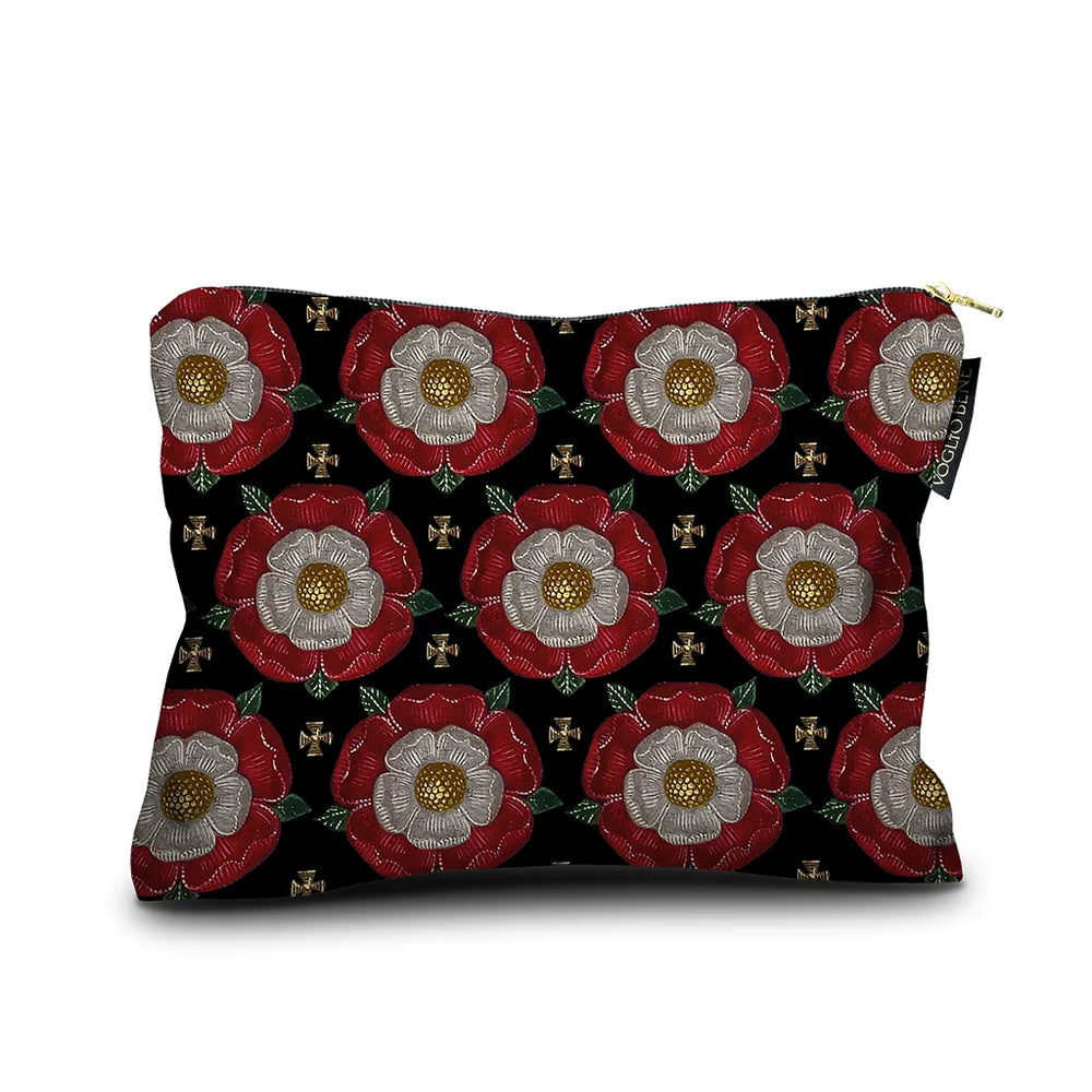 Voglio Bene Notre Dame -samettipussukan takanäkymä, koko 17 × 23 cm. Kukka-aihe toistuu geometrisena kuviona samankaltaisella tummalla taustalla.
Back view of a Voglio Bene Notre Dame velvet pouch, size 17 × 23 cm. The floral motif is repeated as a geometric pattern on a similar dark background.