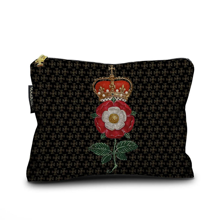 Voglio Bene Notre Dame -samettipussukan etunäkymä, koko 17 × 23 cm. Kuvassa punavalkoinen kukka, jonka päällä on kruunu, mustalla ristiaiheisella taustalla.
Front view of a Voglio Bene Notre Dame velvet pouch, size 17 × 23 cm. The illustration features a red and white flower topped with a crown, set against a black cross-patterned background.