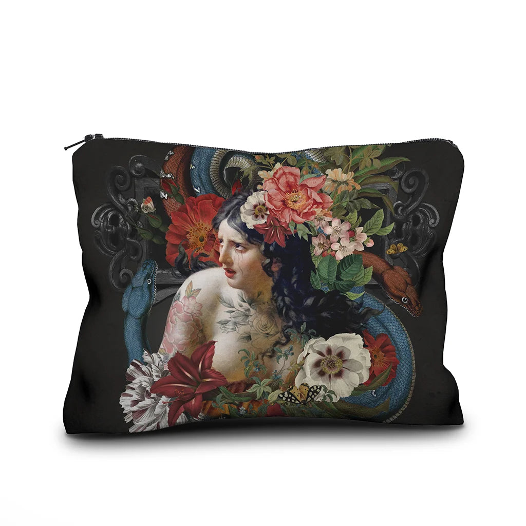 Kuvassa Voglio Bene samettipussukan etupuoli Turmoil -kuvituksella, jossa itkevä tatuoitu nainen on kuvattuna kukkien ja käärmeiden ympäröimänä tummalla taustalla.
In the image, the front side of a Voglio Bene velvet pouch with the Turmoil illustration, depicting a crying tattooed woman surrounded by flowers and snakes against a dark background.