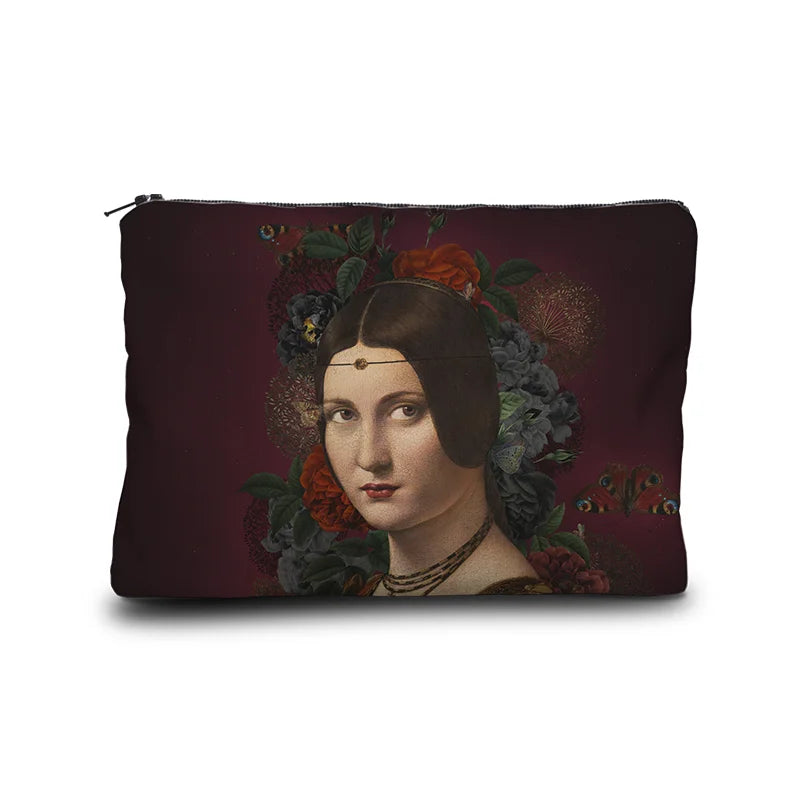 Kuvassa Voglio Bene -kukkaro Bella-kuvituksella. Ruskeahiuksinen nainen punamustalla taustalla, jota koristavat kukat ja perhoset.
The Voglio Bene purse with the Bella illustration. A brown-haired woman stands against a red and black background adorned with flowers and butterflies.