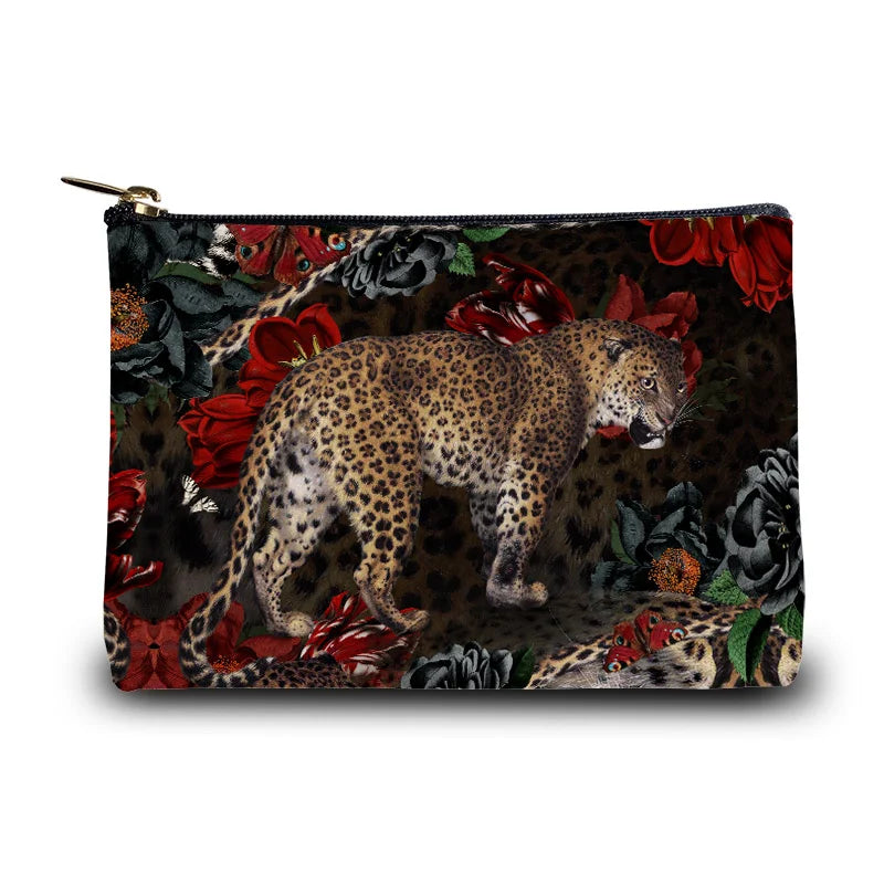 Kuvassa Voglio Bene -kukkaro Fauve-kuvituksella. Edessä leopardi tummalla taustalla kukkien ja perhosten reunustamana.
The front of the Voglio Bene coin purse with the Fauve illustration. A leopard on a dark background surrounded by flowers and butterflies.