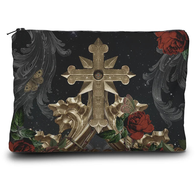Kuvassa Voglio Bene -kukkaron takapuoli Francesca et Paolo -kuvituksella. Kultainen risti kukkien ja ornamenttien kera avaruustaustalla.
The back of the Voglio Bene coin purse with the Francesca et Paolo illustration. A golden cross surrounded by flowers and ornaments against a cosmic background.
