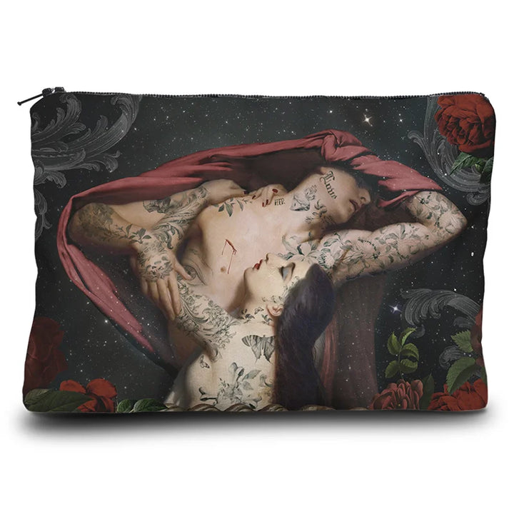 Kuvassa Voglio Bene -kukkaro Francesca et Paolo -kuvituksella. Edessä tatuoitu nainen syleilee tatuoitua miestä, jonka kasvot on peitetty punaisella liinalla. Taustalla avaruus ja kukkien reunus.
The front of the Voglio Bene coin purse with the Francesca et Paolo illustration. A tattooed woman embraces a tattooed man whose face is covered with a red cloth, set against a cosmic background framed with flowers.