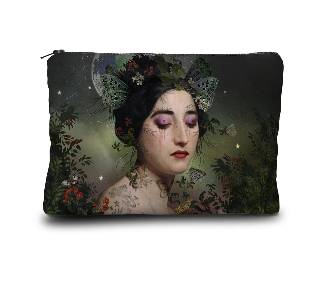 Kuvassa Voglio Bene kukkaron etupuoli Gaia -kuvituksella, jossa tatuoitu nainen perhosia hiuksissaan katsoo alaspäin, taustalla näkyy avaruus ja maapallo ja reunoilla kasveja.
In the image, the front side of a Voglio Bene purse with the Gaia illustration, depicting a tattooed woman with butterflies in her hair looking downward, with space and Earth in the background and plants along the edges.