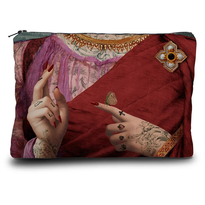 Kuvassa Voglio Bene -kukkaron takapuoli Hope-kuvituksella. Tatuoidun naisen rintakehä punavioletissa asussa tehden käsimerkkejä.
The back of the Voglio Bene coin purse with the Hope illustration. The chest of a tattooed woman in a red-violet outfit making hand gestures.
