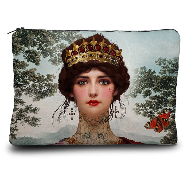 Kuvassa Voglio Bene -kukkaro Hope-kuvituksella. Edessä lähikuva tatuoidun naisen kasvoista kruunu päässään, taustalla vuoria, sininen taivas, oksia ja perhosia.
The front of the Voglio Bene coin purse with the Hope illustration. Close-up of a tattooed woman’s face wearing a crown, with mountains, blue sky, branches, and butterflies in the background.