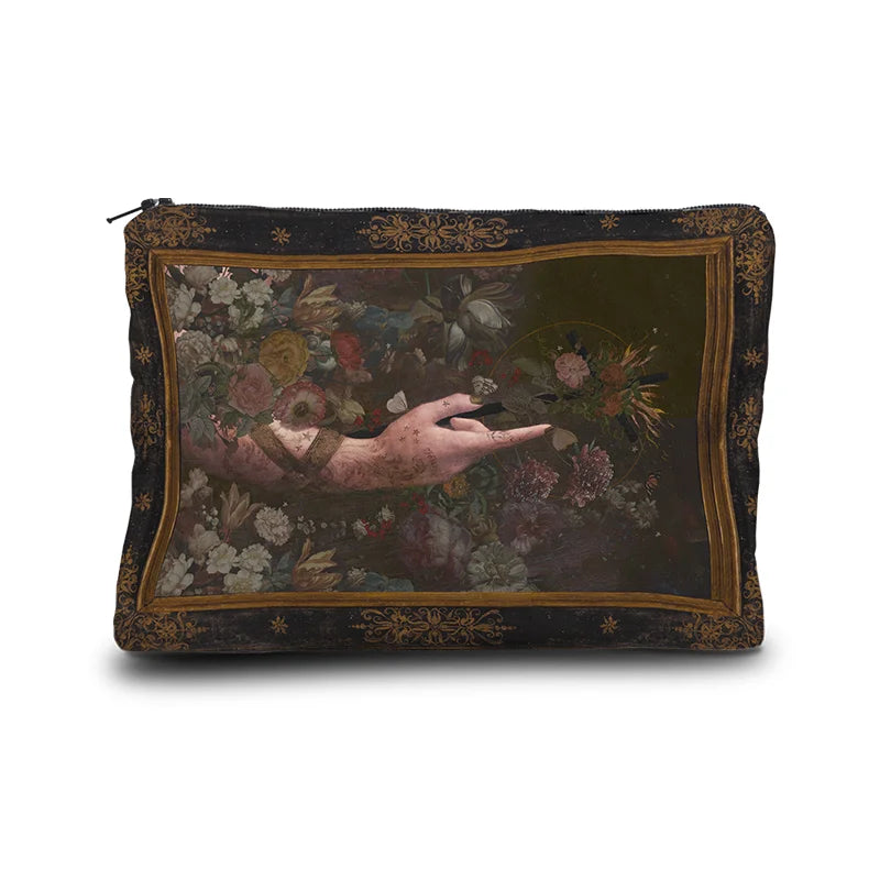 Kuvassa Voglio Bene -kukkaro Il Battista -kuvituksella. Edessä tatuoitu käsi nousee kukkien seasta ja osoittaa oikealle.
The front of the Voglio Bene coin purse with the Il Battista illustration. A tattooed hand emerges from flowers, pointing to the right.