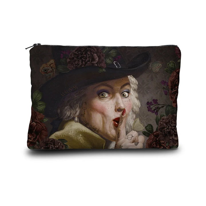 Kuvassa Voglio Bene -samettilaukku The Key Woman -kuvituksella. Joseph Ducreuxin kuuluisa shushing-hahmo tatuoituna ja meikattuna, harmaalla taustalla kukkien reunustamana.
The Voglio Bene velvet bag with The Key Woman illustration. Joseph Ducreux’s iconic shushing figure tattooed and made-up, framed by flowers on a grey background.