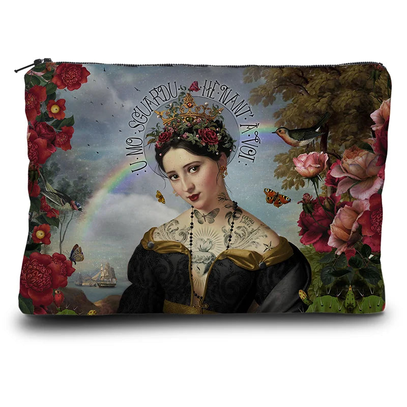 Kuvassa Voglio Bene kukkaron etupuoli Santa di U Niolu -kuvituksella, jossa tatuoitu nainen mustassa mekossa ja kukkaseppele päässä on kuvattuna kukkien reunustamana, taustalla näkyy vettä, sateenkaari ja laiva.
In the image, the front side of a Voglio Bene purse with the Santa di U Niolu illustration, depicting a tattooed woman in a black dress with a flower crown framed by flowers, with water, a rainbow, and a ship in the background.