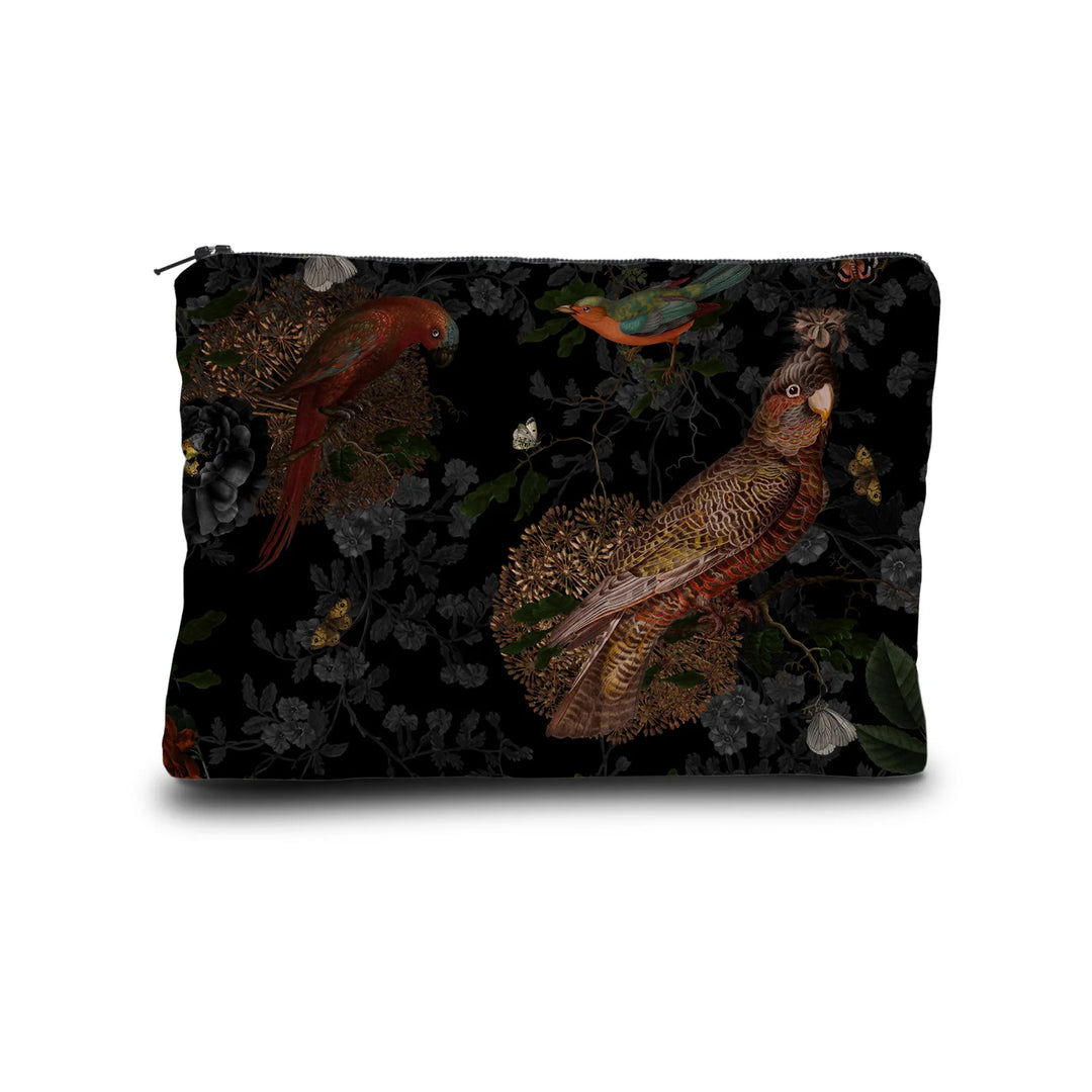 Kuvassa Voglio Bene -kukkaro Rio -kuvituksella. Kaksi papukaijaa, eksoottinen lintu ja perhonen erottuvat mustalla metsätaustalla.
The Voglio Bene purse with Rio illustration. Two parrots, an exotic bird, and a butterfly stand out against a dark forest background.