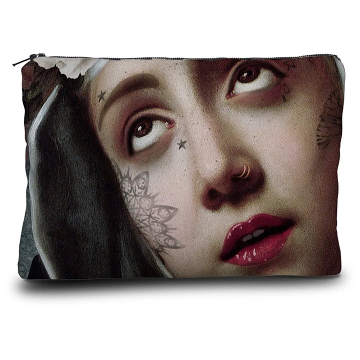 Kuvassa Voglio Bene kukkaron takapuoli Saint Rita -kuvituksella, jossa näkyy naisen kasvot ornamenttikuvion reunustamina.
In the image, the back side of a Voglio Bene purse with the Saint Rita illustration, showing the woman’s face framed by an ornamental pattern.