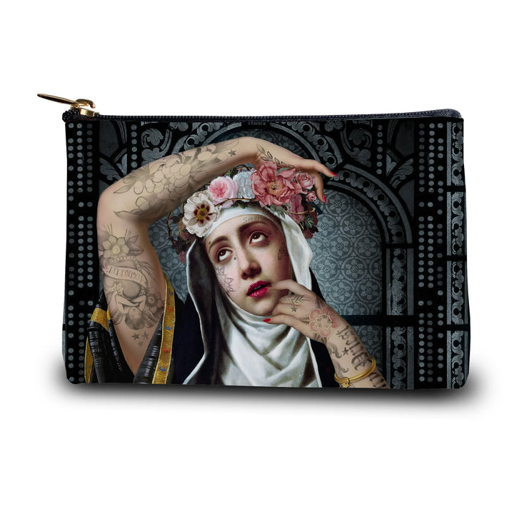 Kuvassa Voglio Bene kukkaron etupuoli Saint Rita -kuvituksella, jossa tatuoitu nunna kukkaseppele päässä on kuvattuna tummalla ornamenttikuvioisella taustalla.
In the image, the front side of a Voglio Bene purse with the Saint Rita illustration, depicting a tattooed nun wearing a flower crown against a dark ornamental background.