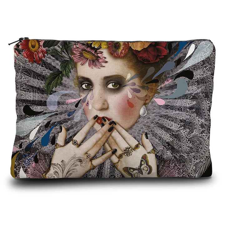 Kuvassa Voglio Bene kukkaron etupuoli Shut Up -kuvituksella, jossa harlekiinimäinen nainen peittää suunsa käsillään, päässään kukkaseppele ja ympärillään kukkia punaisella taustalla.
In the image, the front side of a Voglio Bene purse with the Shut Up illustration, featuring a harlequin-like woman covering her mouth with her hands, wearing a flower crown and surrounded by flowers on a red background.